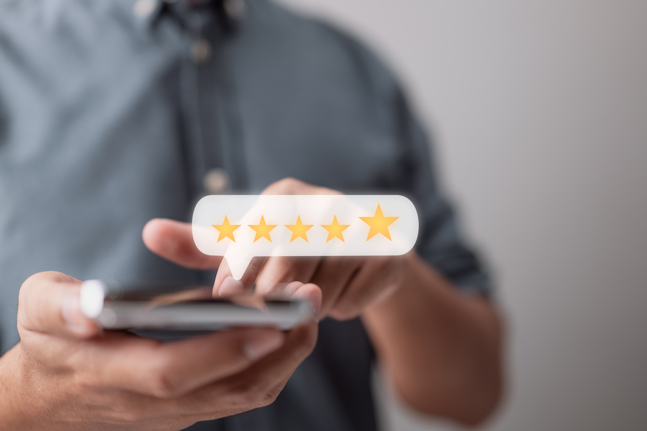 A five-star review is entered into a smartphone. Customer service is one of the most important questions to ask a telephone answering service.